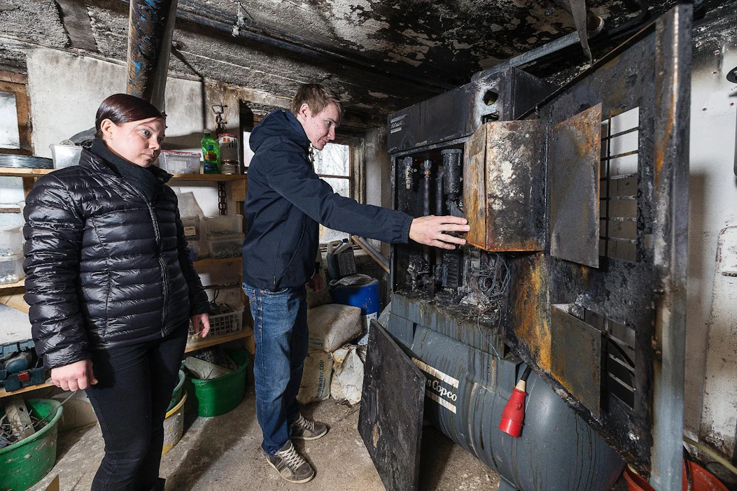Pauli Malmiharju esittelee palanutta lypsyrobotin kompressoria ja hiiltynyttä välikattoa.