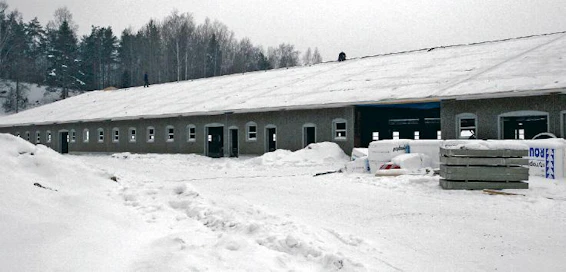 126 metriä pitkä navetta on komea näky. Kattoelementtien yläpinnalla on valmiina alushuopa. Varsinainen vesikattomateriaalina toimiva huopa asennetaan jälkikäteen.