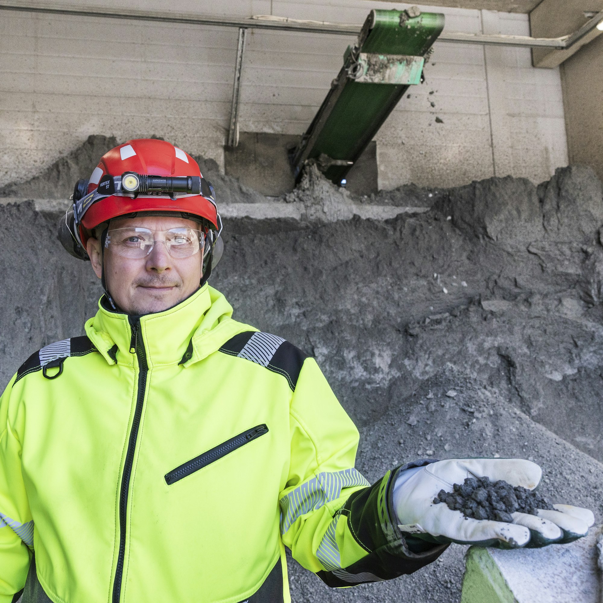 Endomines Oy:n kehitysjohtaja Sampo Hirvonen pitelee kädessään kultarikastetta. Taustalla olevassa kasassa rikastetta on noin 45 000 euron arvosta.