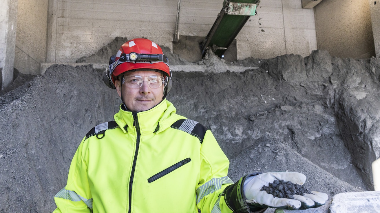 Endomines Oy:n kehitysjohtaja Sampo Hirvonen pitelee kädessään kultarikastetta. Taustalla olevassa kasassa rikastetta on noin 45 000 euron arvosta.