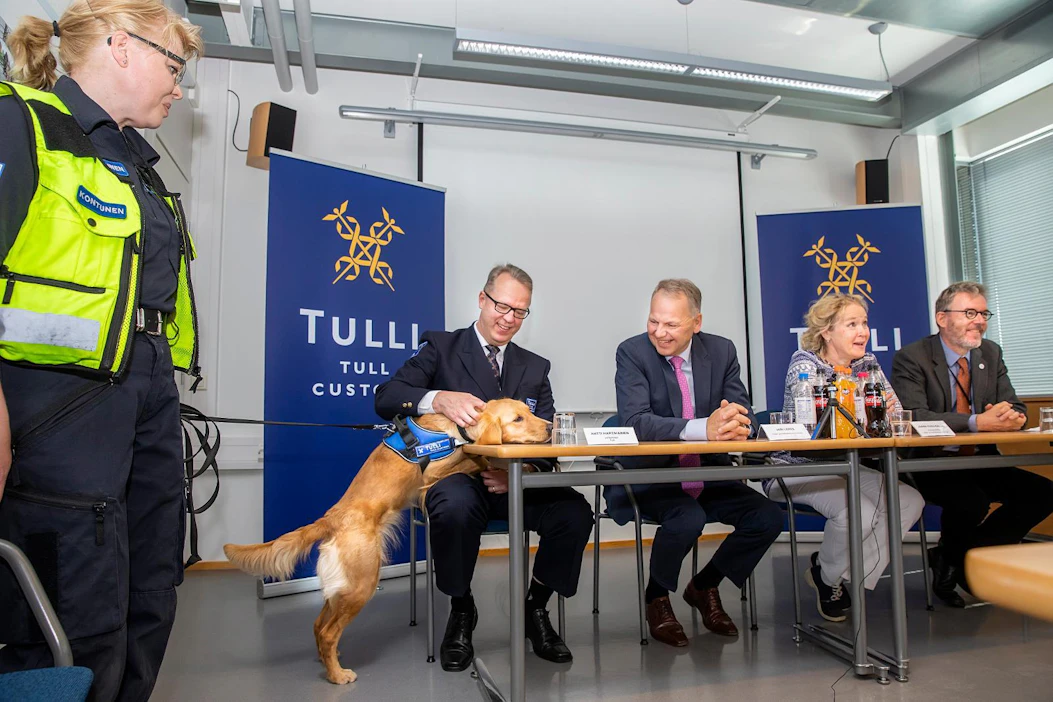 Tullin ruokakoira Aino esittäytyy ohjaaja Seija Kontusen kanssa. Vasemmalla Tulln pääjohtaja Antti Hartikainen, maa- ja metsätalousministeri Jari Leppä, maa- ja metsätalousministeriön kansiliapäällikkö Jaana Husu-Kallio ja Eviran pääjohtaja Matti Aho.