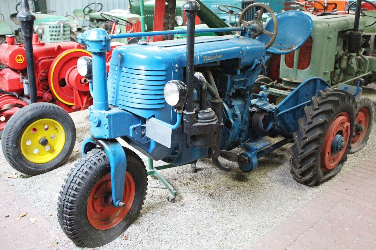 Karl Ritscher oli 1920-luvulta alkaen merkittävä telatraktoreiden ja -alustojen tekijä, opit oli saatu Clevelandin tehtailla USA:ssa. 3-pyöräisten traktoreiden tekeminen alkoi vuonna 1936, mutta tavoitteena ei ollut riviviljelytyyppi, vaan yksinkertainen rakenne. Sotien jälkeen tuotanto jatkui mallilla 320, josta oli saatavana myös 4-pyöräinen versio 420. Moottorina oli 2-sylinterinen Deutz tai MWM, tasauspyörästönlukko oli vakiona, voimanottoakseli ja keskiniittokone valinnaisvarusteena. (Sonsbeck)