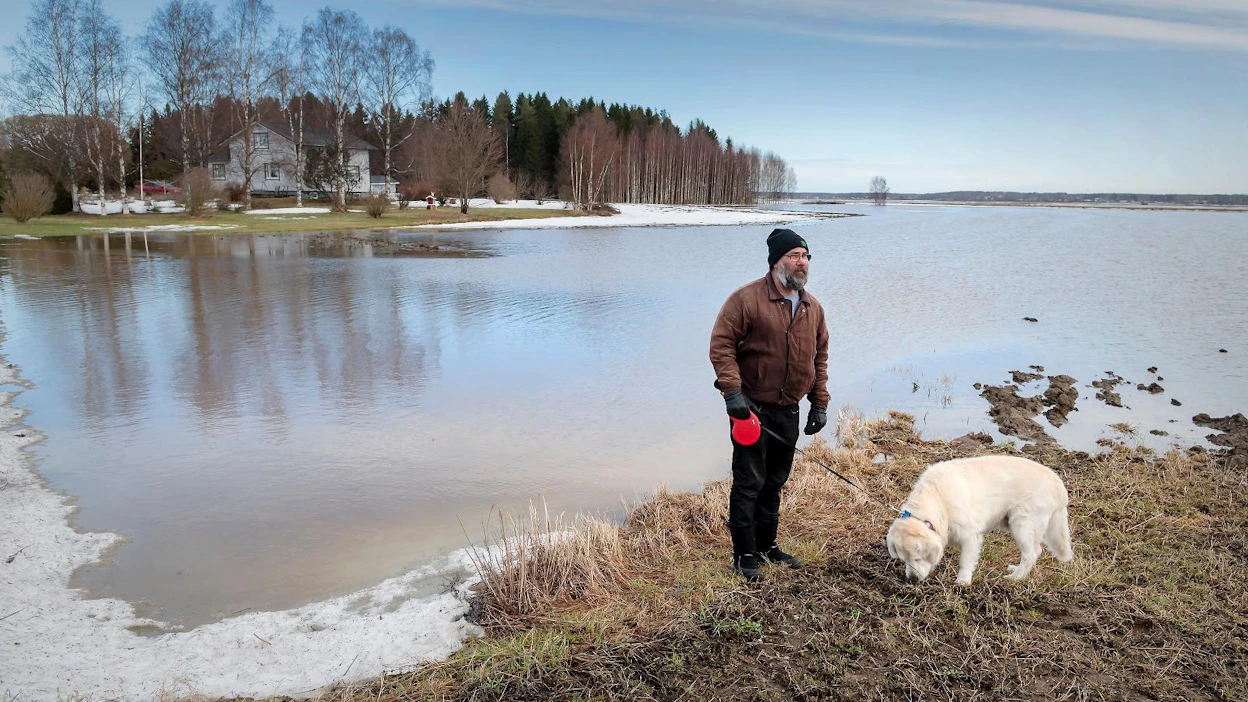 Timo Mäkinen ja Jesse silmäilivät tulvajärveä Ylihärmän Ikolassa tiistaina 30.3. Mäkisen talo näkyy taustalla.