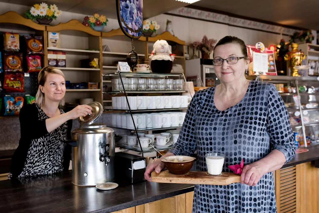 Mutti on valmis nautittavaksi, Liisa Harju tarjoilee annoksen. Myyntitiskin takana on seuraavan polven huoltamoyrittäjä Hanna Kinnunen.