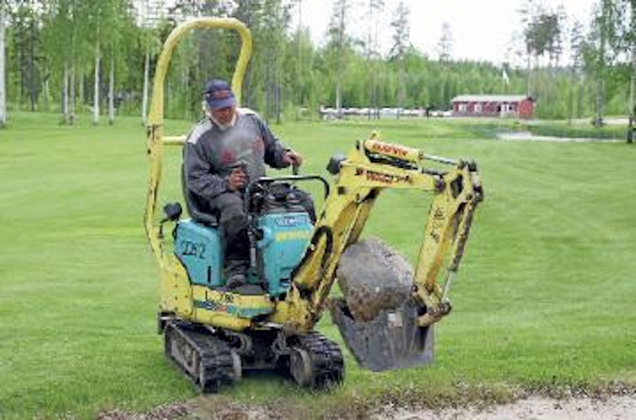 Minikone urakoimassa Tervon Eerikkala Golfin ykkösväylällä. Hiekkaesteessä ollut kivi irtosi helposti, eikä väylälle jäänyt teloista juurikaan jälkiä. Väylän sivussa sijainneen, halkaisijaltaan 25-senttisen koivunkannon irrotus oli pikkukaivurille liian vaativa kohde.