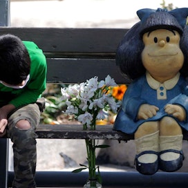 Ihmiset jättivät sarjakuvataiteilijan muistoksi kukkia Mafaldaa kuvastavan patsaan luokse.