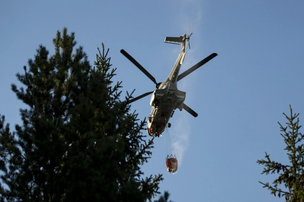 Paikalla sammutustöissä on noin 200 ihmistä, ja paloa sammutetaan myös helikopterilla. LEHTIKUVA / RONI LEHTI