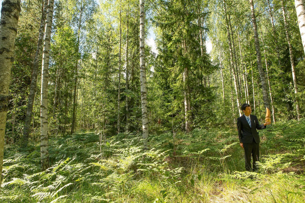 Iwao Uehara on vienyt Japanissa muun muassa dementiapotilaita metsään. Kädessään hänellä on metsätonttu esittävä patsas.