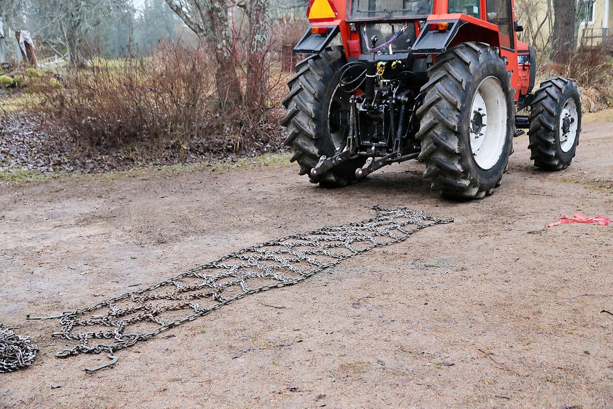1. Asennus aloitetaan asettamalla ketju maahan, nastat ylöspäin. Ketju oikaistaan suoraksi ja sen ketjulenkit silmäillään läpi – tässä vaiheessa on helppoa havaita, onko ketjussa toisiinsa jumiutuneita tai väärässä asennossa olevia lenkkejä.