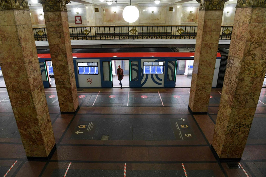 Matkustaja nousee Moskovassa metroon tyhjällä asemalla. Laiturin pinnassa on merkintöjä, joiden avulla voi huolehtia etäisyyden pidosta toisiin ihmisiin. LEHTIKUVA / AFP