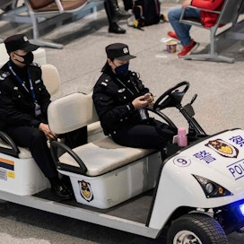 Hengityssuojaimin varustautuneita poliiseja kulkuneuvossaan Pekingin Daxingin kansainvälisellä lentoasemalla 21. tammikuuta. LEHTIKUVA/AFP