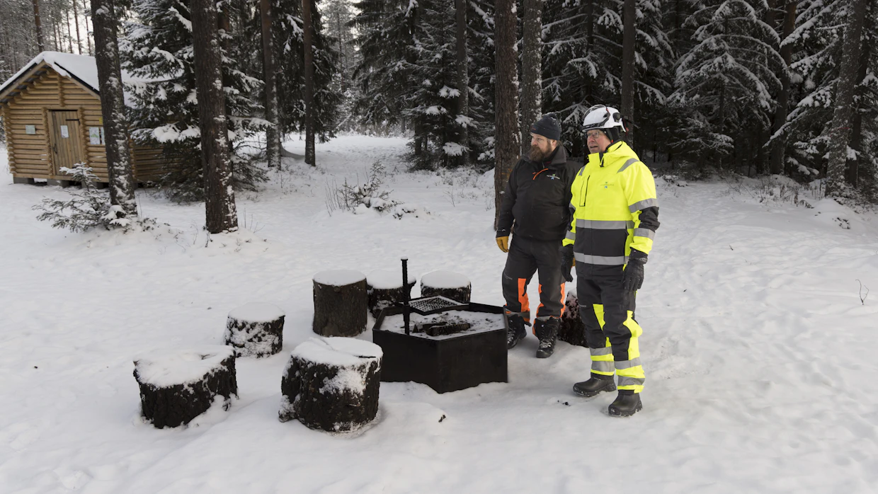 Metsähallituksen Luontopalveluiden rakentamisen erityisasiantuntija Ville Nikkinen ja kenttäpäällikkö Jouni Kosonen esittelevät vanhaa nuotiopaikkaa Sanginjoen varressa. Tilalle tulee sadan neliön nuotiokatos, johon tulee neljä tulisijaa.
