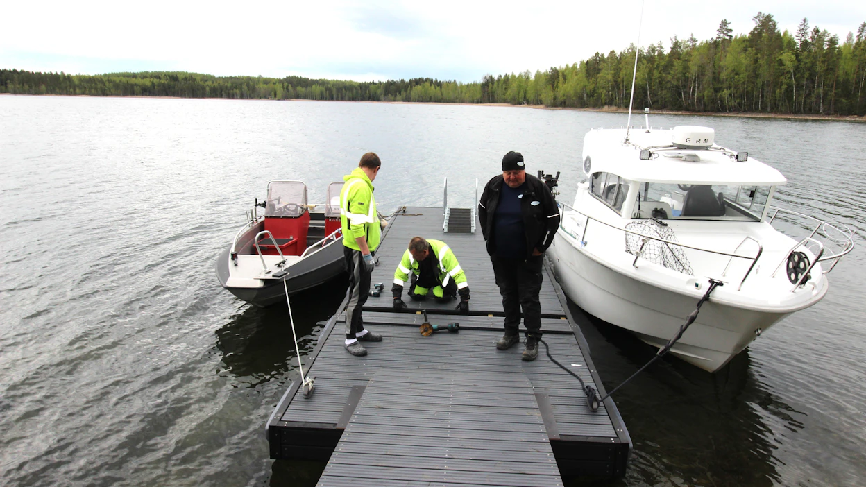 Laiturin ja kävelysillan suuntaus tarkistetaan jälkikäteen. Tarmo Eronen säätää suuntauksen kohdalleen. Laiturilla myös omistaja Tero Manninen (vas.) ja Johannes Laukkanen.