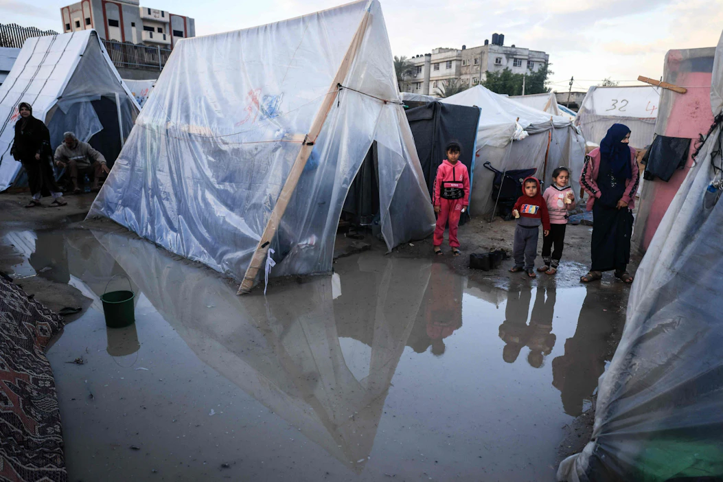Palestiinalaisia lauantaina Rafahissa Gazan eteläosassa hätämajoitukseksi kyhätyissä teltoissa, jotka rankkasade on kastellut. AFP / LEHTIKUVA.