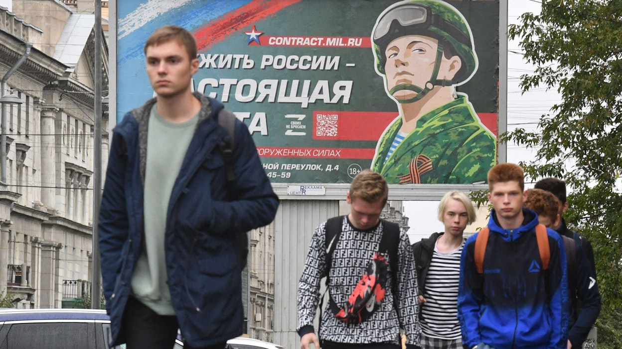 Nuoria miehiä käveli armeijan ulkomainoksen edessä Pietarissa torstaina. LEHTIKUVA/AFP. 
