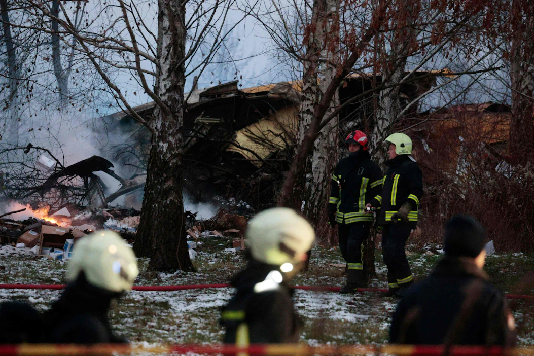 Pelastustyöntekijöitä maahan syöksyneen rahtikoneen jäänteiden luona Vilnassa maanantaiaamuna. LEHTIKUVA / AFP .