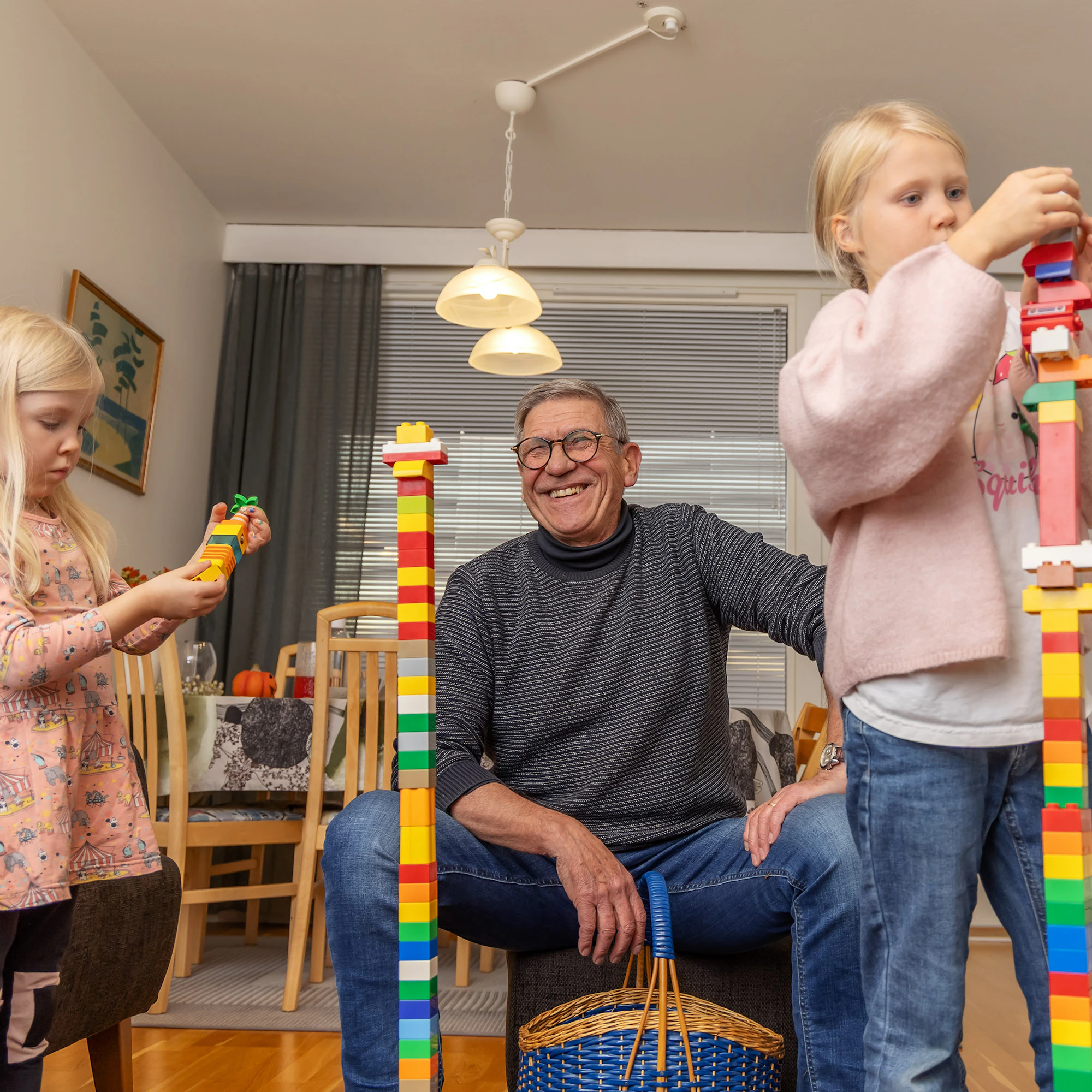 Saima (vas) ja Seela Harmokivi rakentavat pappansa Ali Harmokiven kanssa Helsingin Kontulassa.