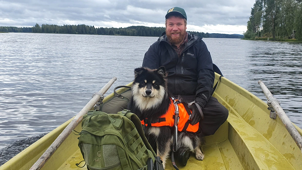 Tuomas Pelkonen veneilemässä lapinkoira Jörön kanssa.
