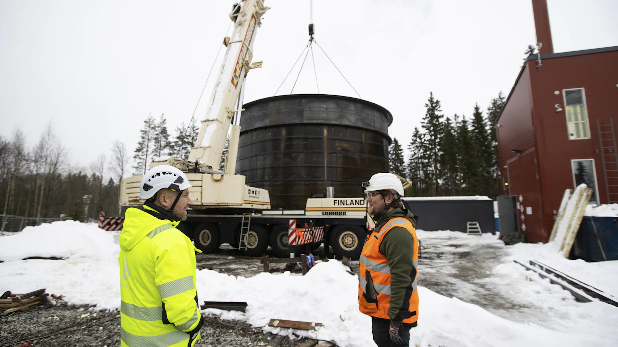 Loviisan Lämmön toimitusjohtaja Mikko Paajanen (vas.)ja Polar Night Energyn vastaava työnjohtaja Jouni Uusipuro kuvattuna Pornaisissa joulukuussa, kun kaukolämpöön hiekkaan varaavan akun kattorakennelma nostettiin paikoilleen.
