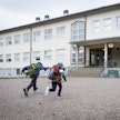Lapsia kiirehtimässä tunnille. Kuvituskuva.