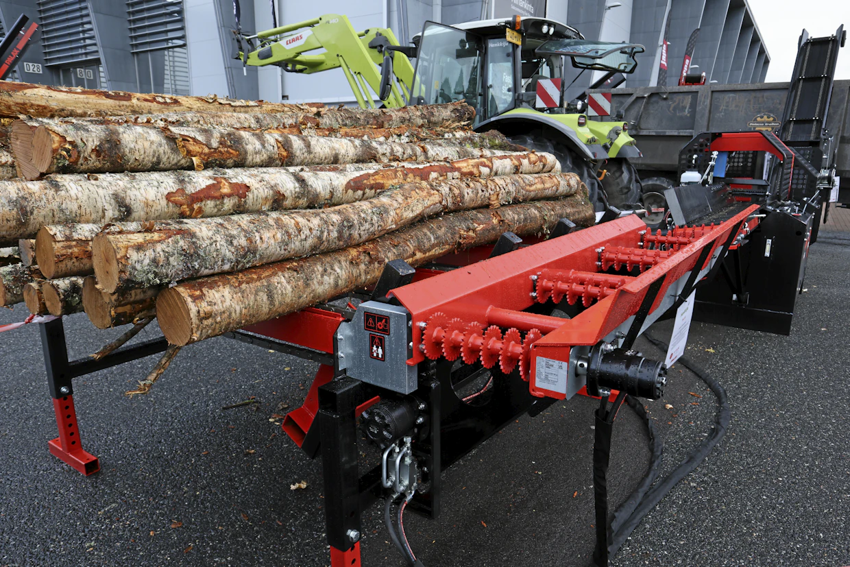 Palax Mega -syöttöpöydässä rangat ”pompautetaan” syöttörullille neljällä työntimellä. Kuvassa työntimet ovat ala-asennossa. Kun rankapöydän kasaa ajetaan mustia vinotukia vasten, alhaalta työntyvät nostimet työntävät rangan mustien tolppien yli.