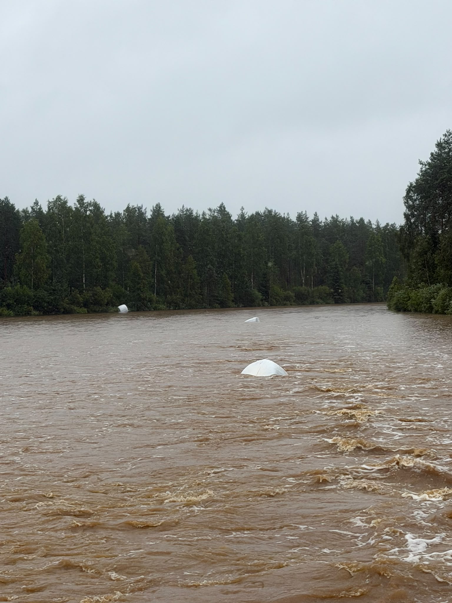 Kevyehköt heinäpaalit lähtivät vesimassan mukana liikkeelle pellolla.