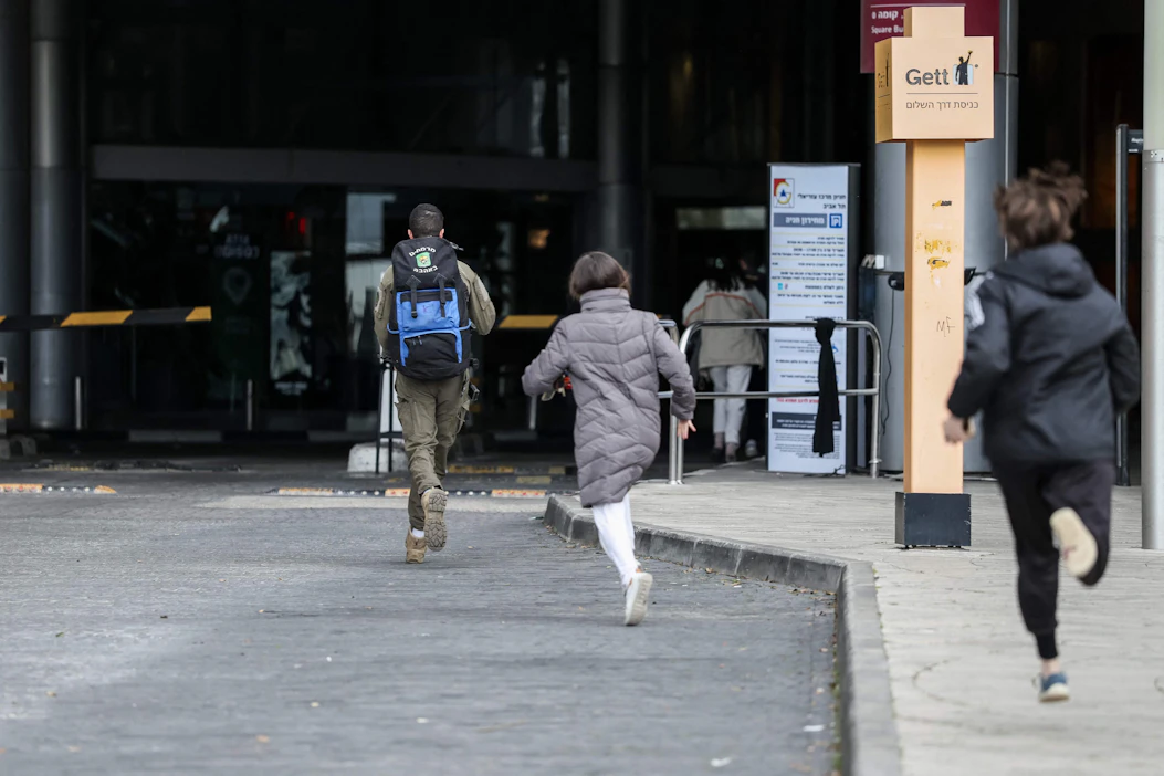 Tel Avivissa ihmiset kiirehtivät suojaan hälytyssireenien soidessa lauantaina. LEHTIKUVA/AFP.