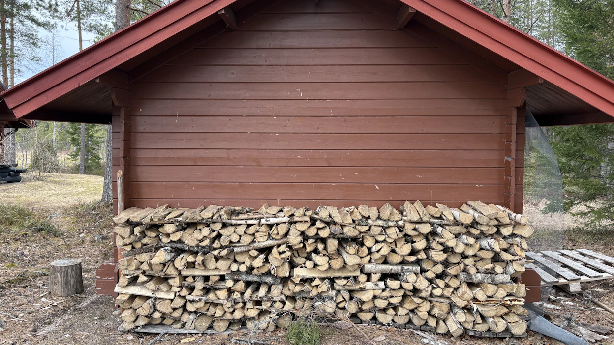 Puupino seinustalla. Tämä pino purettiin heti kuvan ottamisen jälkeen. Kuvituskuva.