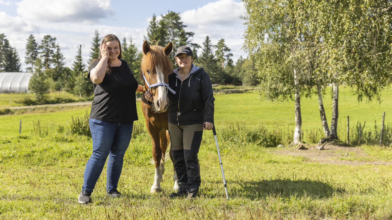 Ida Harlin (vas.) ja Liisa Hytönen kunnioittavat suomenhevosia. Kuvassa myös ori Kipinän Toivo.