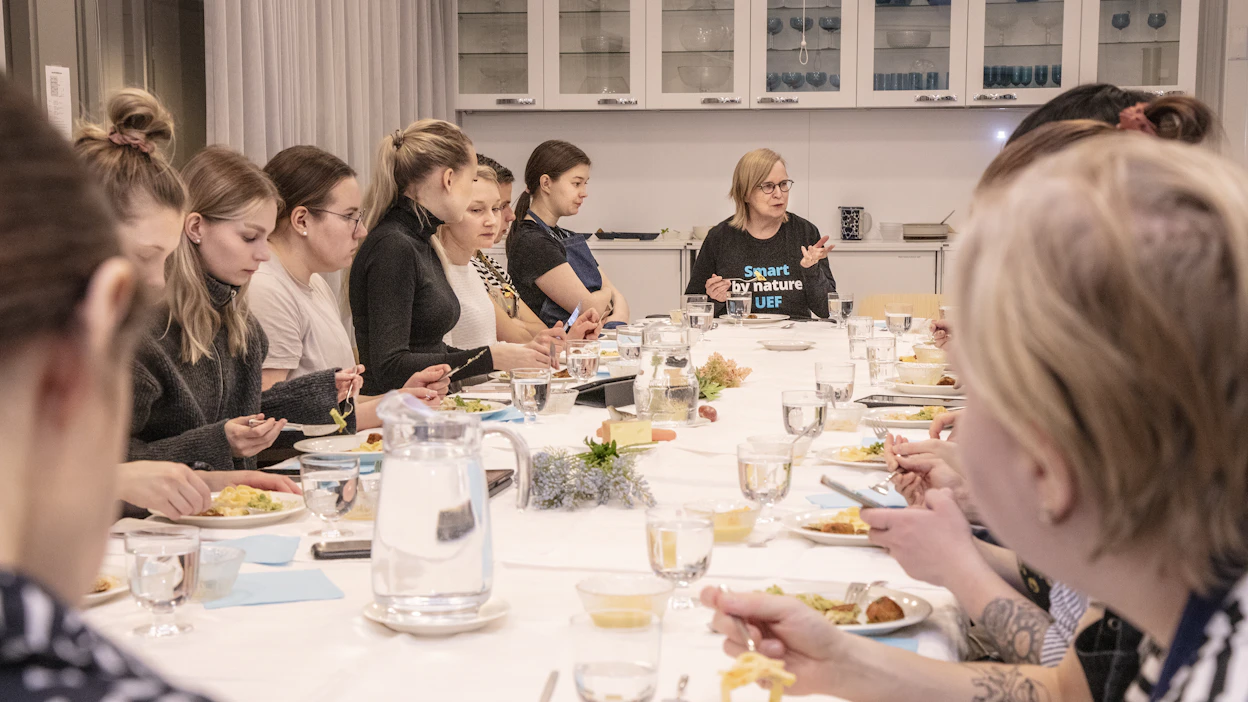 Tärkeä osa kotitaloustieteen opiskelua on pöydän kaunis kattaminen sekä itse valmistetun aterian nauttiminen yhdessä. Pöydän päässä alan professori Hille Janhonen-Abruquah Itä-Suomen yliopistosta.