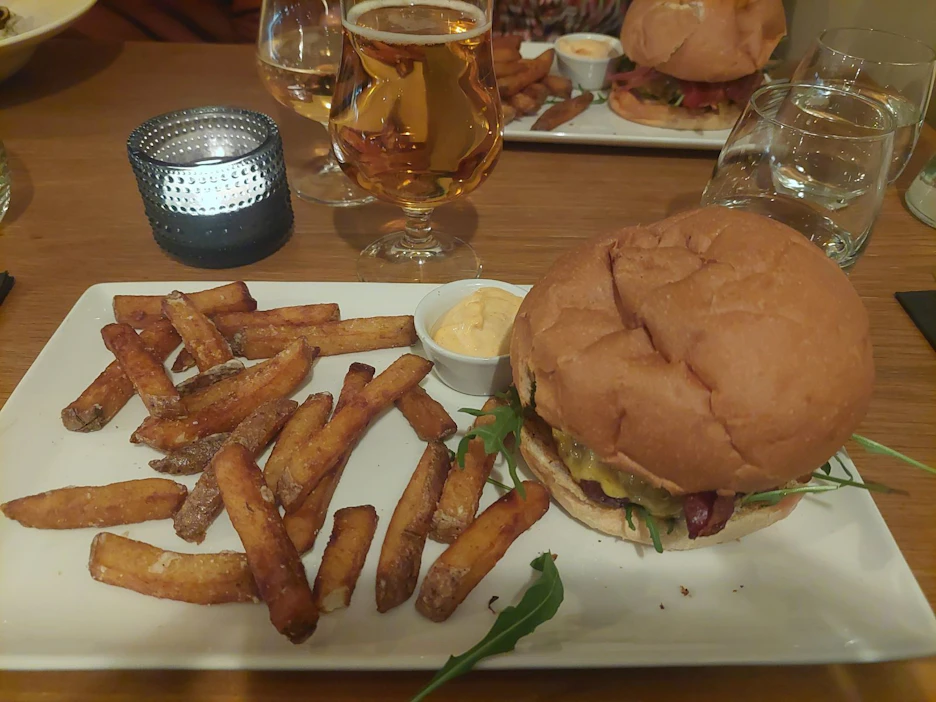 Neran burgeri sisältää naudan jauhelihapihvin, karamellisoitua pekonia, cheddar-juustoa, pikkelöityä punasipulia, talon ranskalaiset ja suolakurkkumajoneesia.