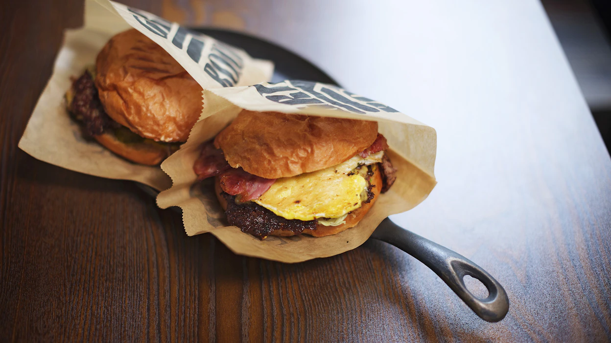 Kuvassa kolmen vartin odottelun jälkeen pöytään tuodut Grill Roomin "smash burgerit" OG Onion (12 euroa) ja Snägäri (11,50 euroa).