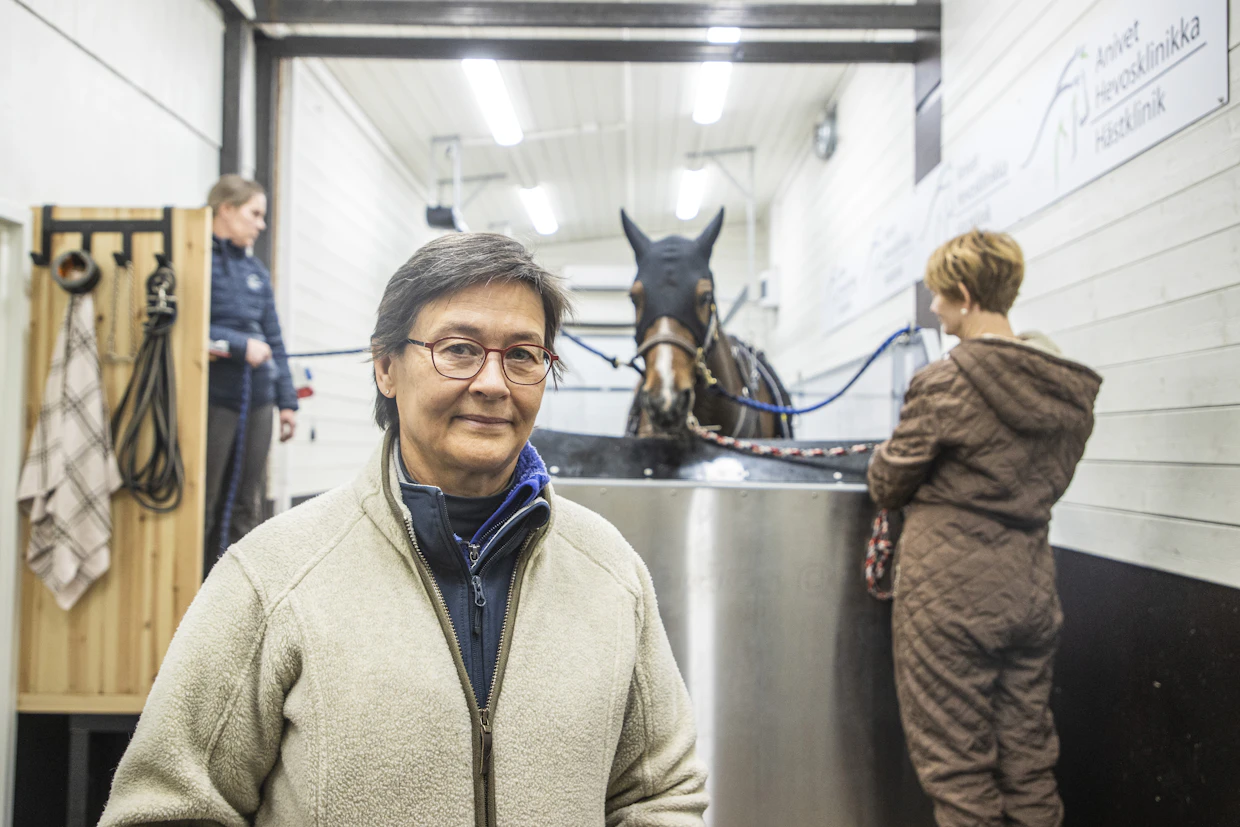 Anivetin viime vuosien investointeja on ollut hevosten vesikävelymatto, jota käytetään monipuolisesti kuntoutuksessa. Matolla Iina-hevonen vierellään omistajansa Marjo Helelä ja eläintenhoitaja Petra Ulmonen.