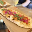 Valkoinen Tyyne-pizza sisältää smetanakastiketta, kylmäsavulohta, pikkelöityä punasipulia ja tuoretta tilliä.