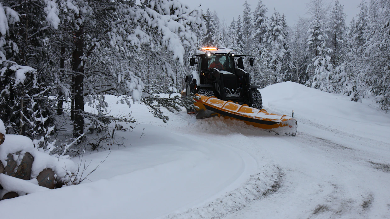 Etukuormaajaan kiinnitetty alueaura on paikallaan, kun isojen pihojen lumia on pukattava korkeiksi valleiksi. Puskutuet ovat välttämättömät etukuormaimessa.