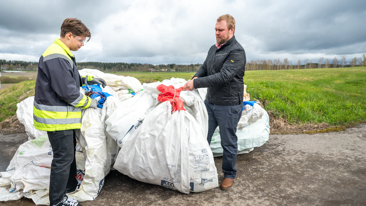 4H -työntekijä Otto Hänninen (vas.) ja viljelijä Tuomas Nummela pinoamassa kerättyjä säkkejä. Kuva otettu viime vuoden keräyksestä.