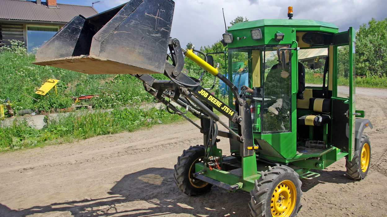 Omatekoisen, nelivetoisen Job Deere -pihakuormaimen etukuormain on varustettu kauhan asennon vakaajalla sekä pikakiinnikkeellä.