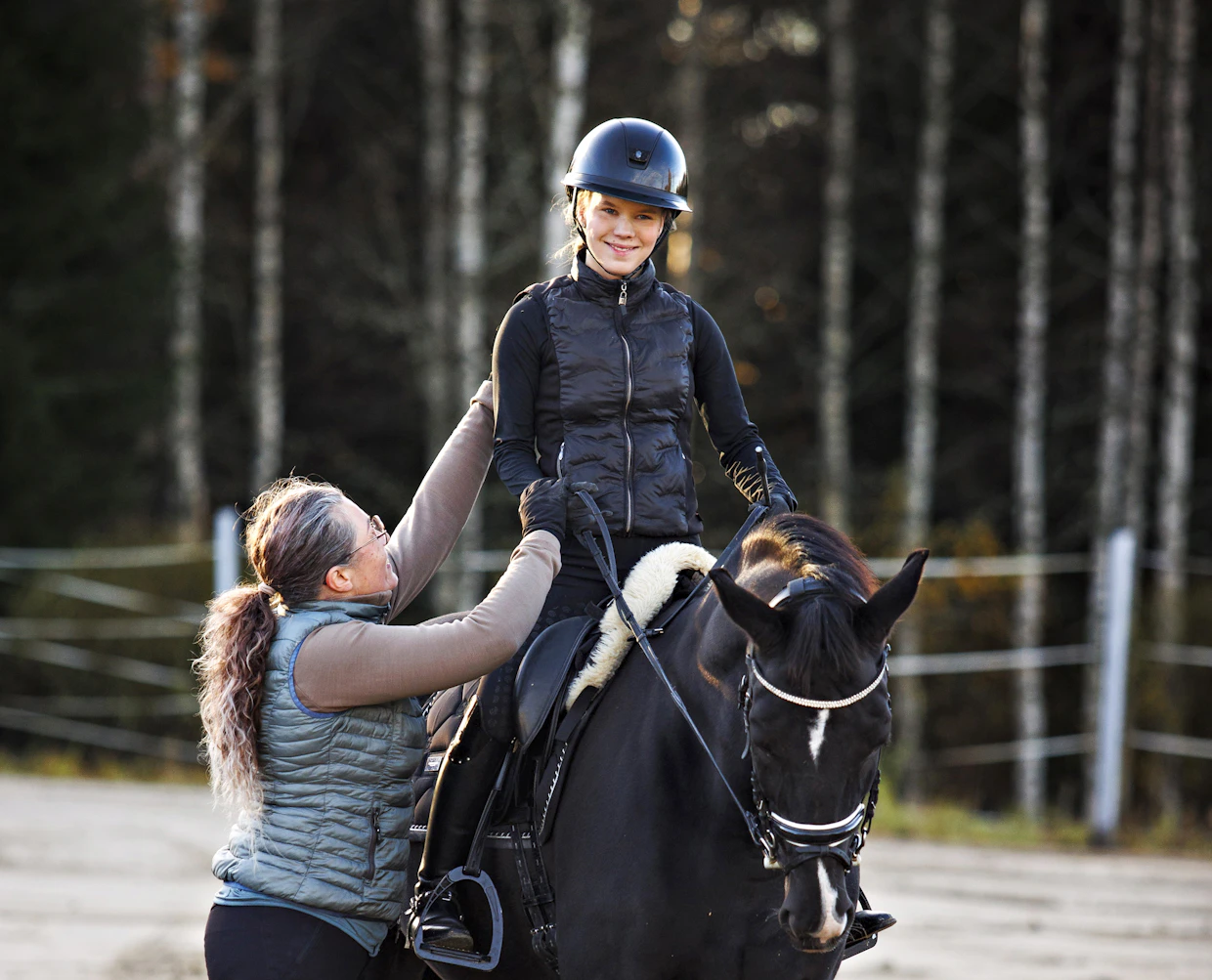 Katariina Petsalo havainnollistaa Fiona-hevosella ratsastavan Vilma Alirannan avulla istunnan korjaamista.