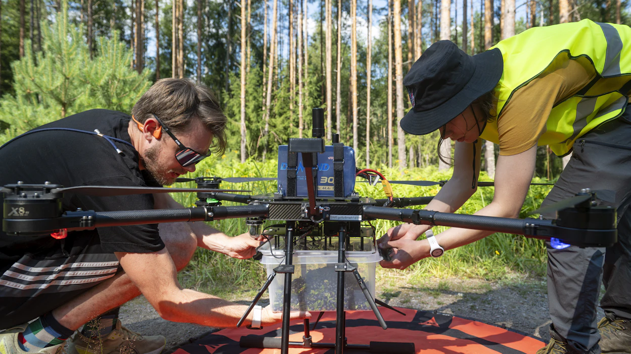 Marjalastia purkamassa droonin kyydistä droonin lennättäjä Erik Österberg ja testaajana toimiva Eino Paronen.