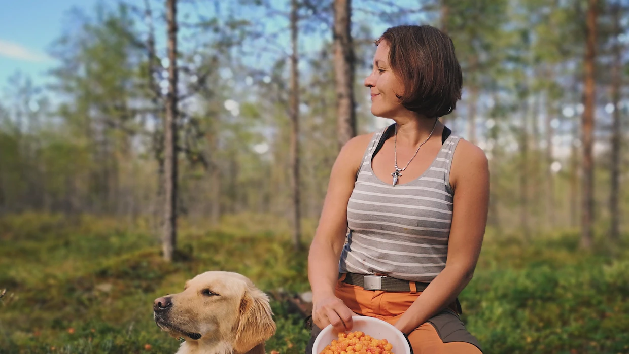 Susanna Kinnunen kuvaa usein soilla. Tässä kuvassa hän poseeraa Ilo-koiran kanssa. Marjastus on Kinnusella verissä. ”Se hulluus tosiaan periytyy. Pian pääsee taas juoksentelemaan lakkasangon kanssa”, hän iloitsee.