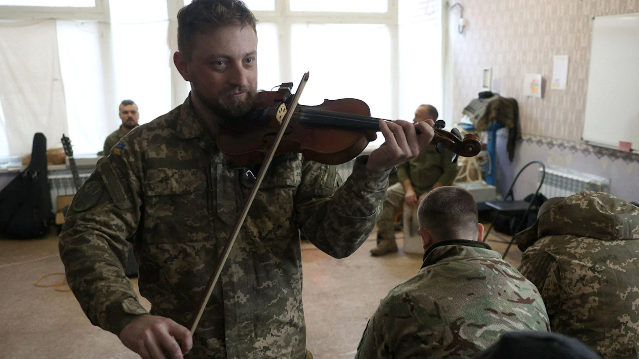 Ukrainalaisia sotilaita kuuntelemassa Kulttuurijoukot-ryhmän musiikkia Donetskin alueella. LEHTIKUVA / AFP .