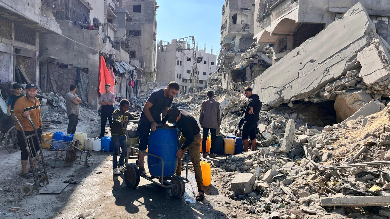 Asukkaita noutamassa puhdasta vettä raunioiden keskellä Beit Lahiassa Gazan pohjoisosassa sunnuntaina. LEHTIKUVA/AFP.