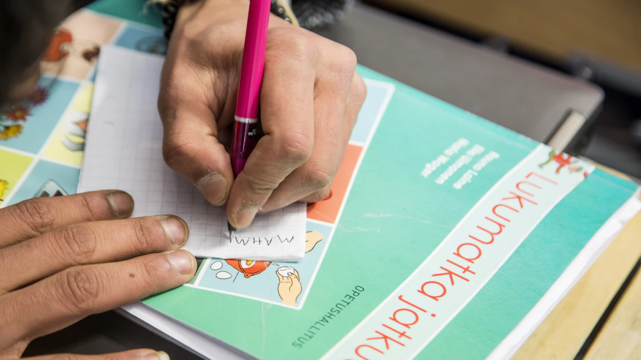 Suomen kieltä oppimassa. Kuvituskuva.