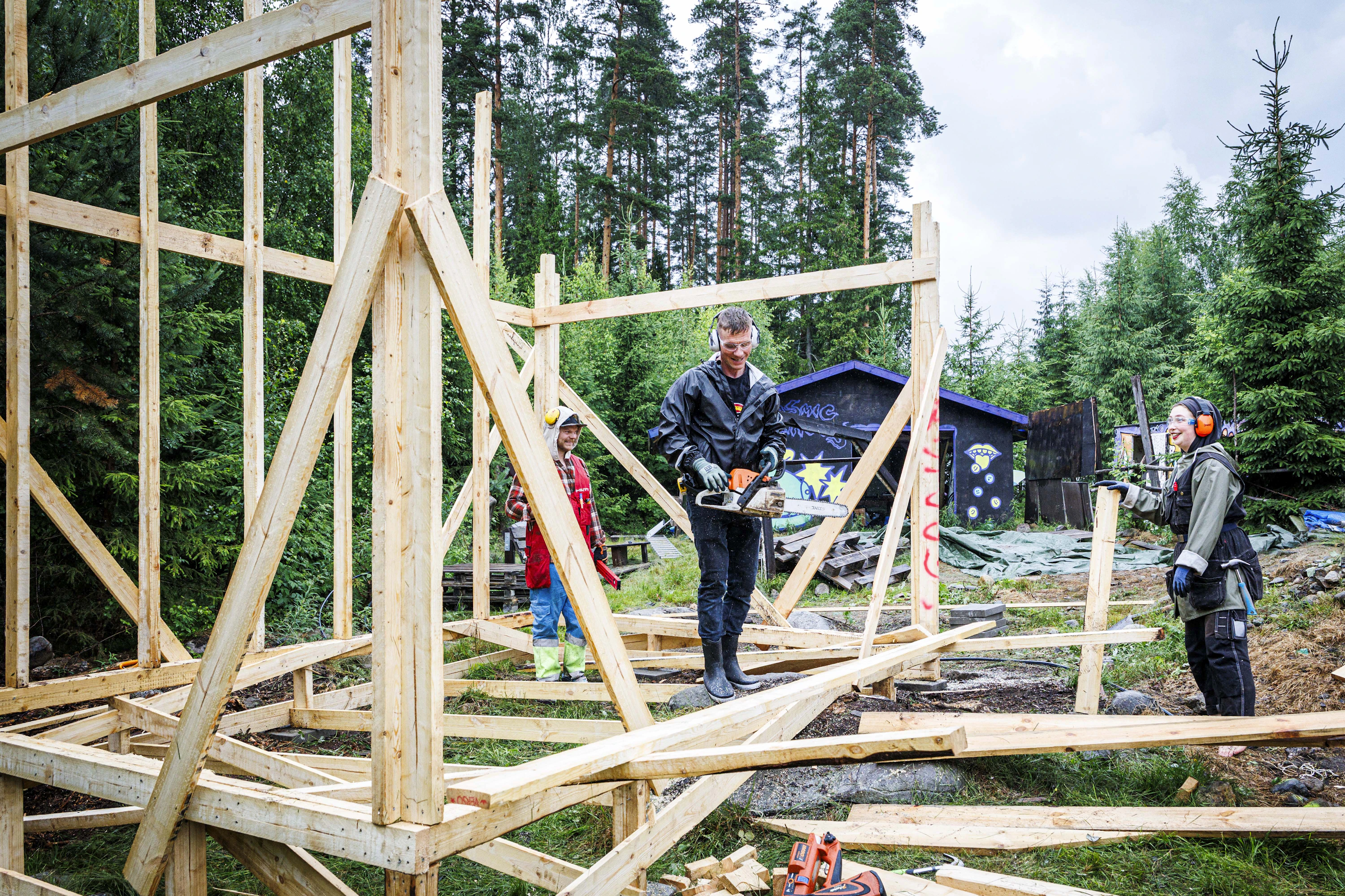 Rakennusmestari John Lehmuspuro (kesk.) on vastuussa korkeasta lavarakenteesta. Mukana rakentamassa Mikael Porjo (vas.) ja Dagmar Ilonoja.