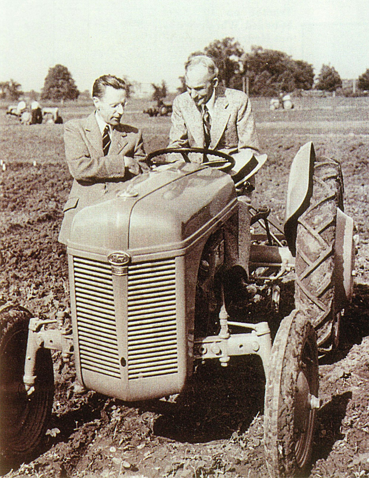 Yli 10 vuoden tauon jälkeen Ford aloitti traktorituotannon v.1939 uudella 9N-mallilla, jossa oli Fergusonin hydraulinen nostolaite painonsiirtojärjestelmineen. Yhteistyö päättyi 8 vuotta myöhemmin, välirikko johtui Fordille tappiollisesta ja Fergusonille hyvinkin tuottoisasta voitonjaosta. Kuvassa Harry Ferguson esittelee ohjaimissa olevalle Henry Fordille traktorin hienouksia. 