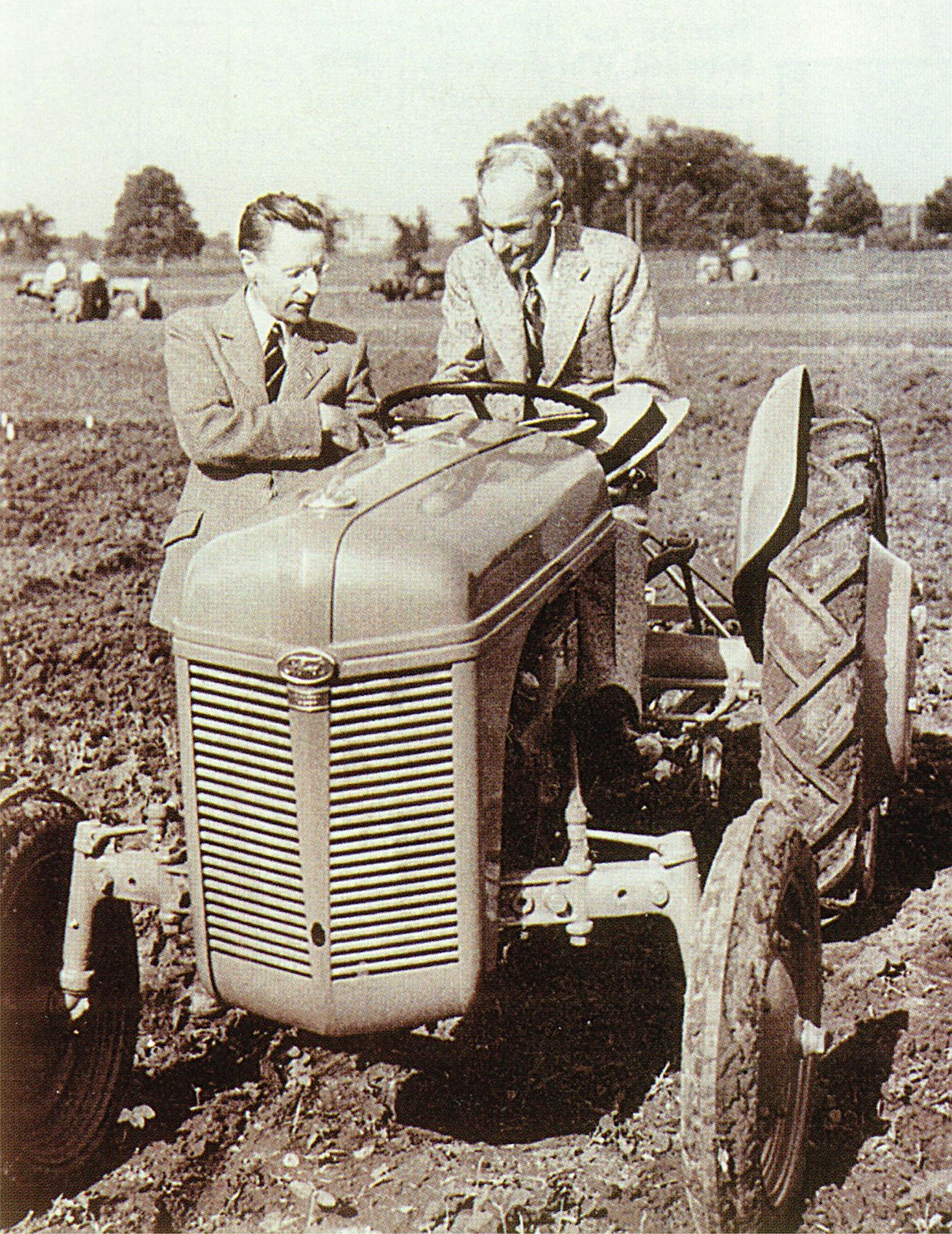 Yli 10 vuoden tauon jälkeen Ford aloitti traktorituotannon v.1939 uudella 9N-mallilla, jossa oli Fergusonin hydraulinen nostolaite painonsiirtojärjestelmineen. Yhteistyö päättyi 8 vuotta myöhemmin, välirikko johtui Fordille tappiollisesta ja Fergusonille hyvinkin tuottoisasta voitonjaosta. Kuvassa Harry Ferguson esittelee ohjaimissa olevalle Henry Fordille traktorin hienouksia.