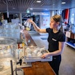 Palvelupäällikkö Aliina Vinkka lataa laseja lounasvieraiden käyttöön Alvariinissa.