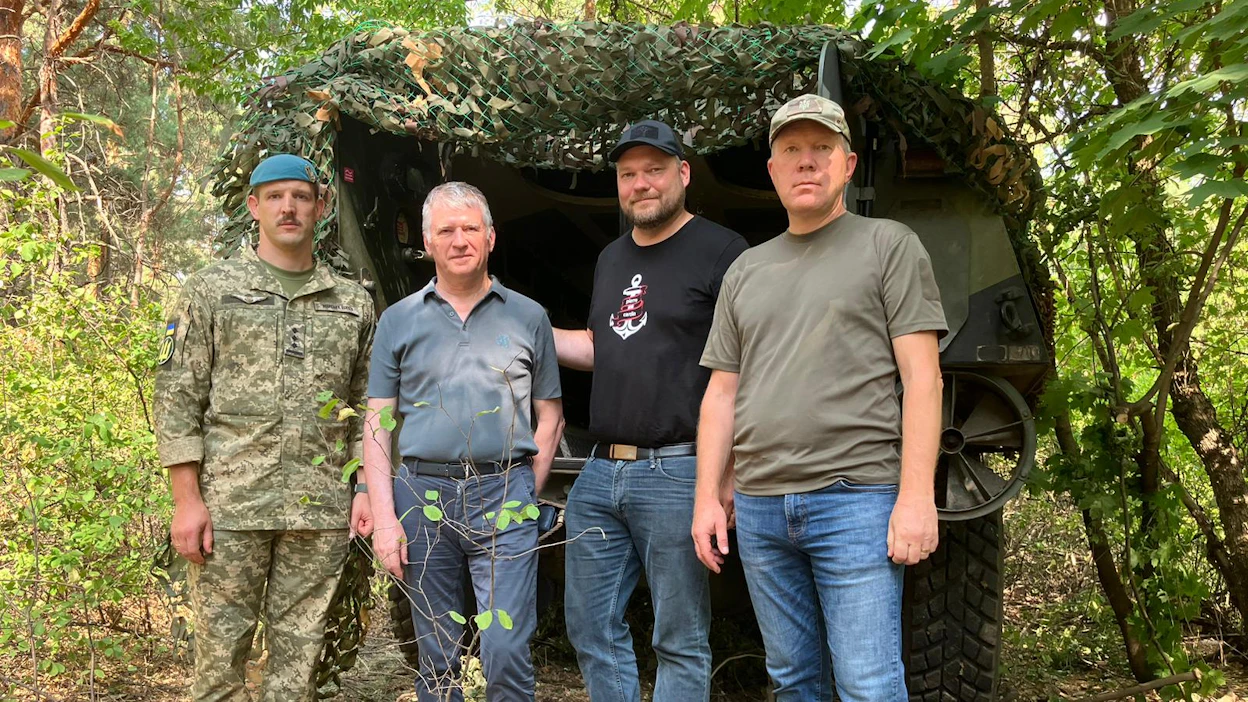 Ukrainalainen eversti Vitkov, ranskalainen Philippe Folliot, Mikko Savola ja Viron Marko Mihkelson poseeraavat Harsovan alueella suomalaisen panssarisisun edessä.