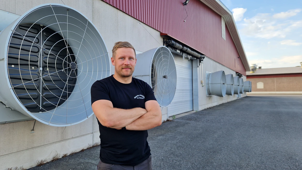 Kalle Mahlamäki kertoo, että broilerkasvattamoissa on alipaineilmastointi. Kuvassa hänen takanaan näkyviä jättipuhaltimia käytetään pääasiassa helleaikaan.