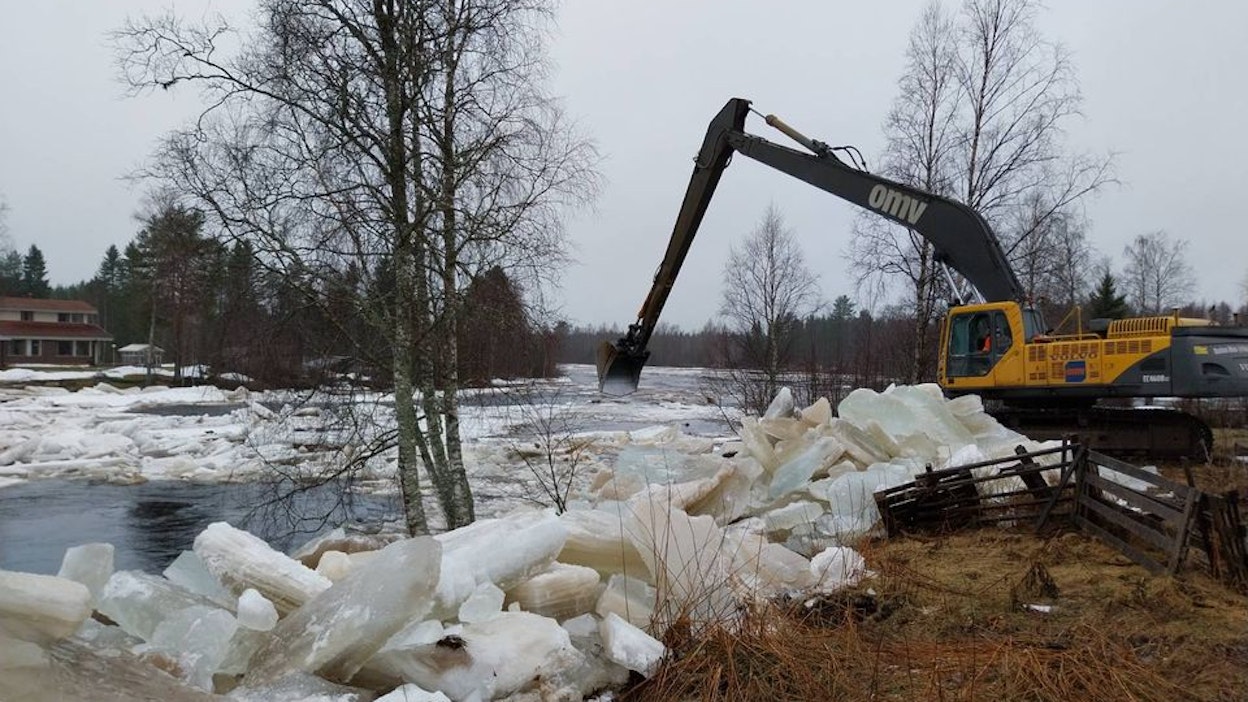 Jääpatoja puretaan Kiiminkijoella kaivinkoneella.
